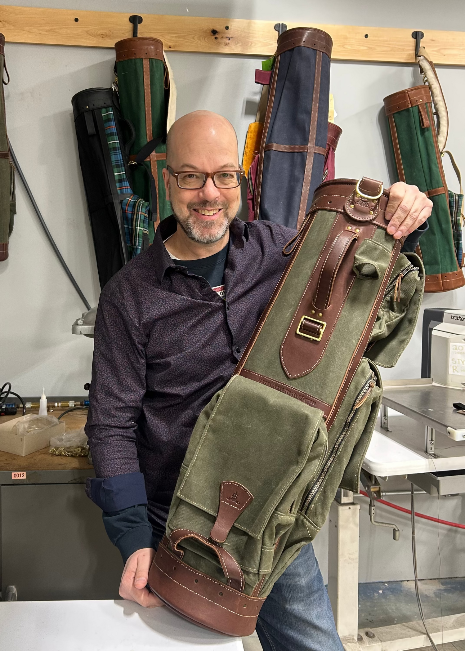 Steve Kriesel, the new owner of S&J stands with a Gran Tour golf bag in the shop
